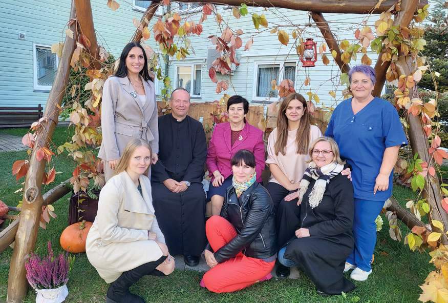 Senelių globos namų kolektyvas šventėje įsiamžino su parapijos klebonu kun. Žydrūnu Kulpiu.