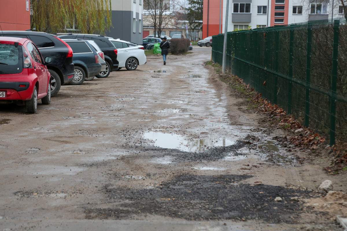 Jaunimo g. 14-ojo namo gyventojų automobiliai – erdvioje aikštelėje, bet iki jos – keistai vingiuotas, duobėtas ir purvinas keliukas.