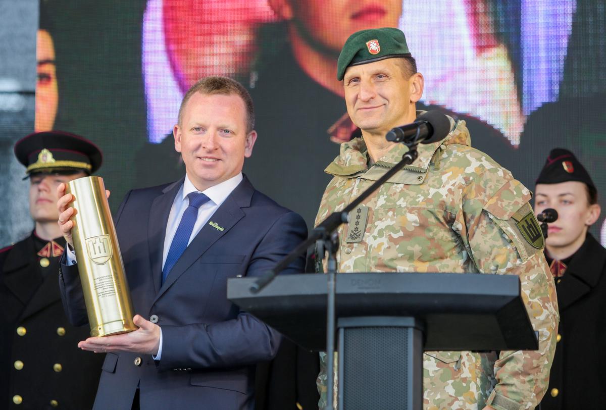 Kariuomenės vadas gen. Raimundas Vaikšnoras Marijampolės savivaldybės merui Povilui Isodai kaip pagarbos ženklą įteikti tūtą. 