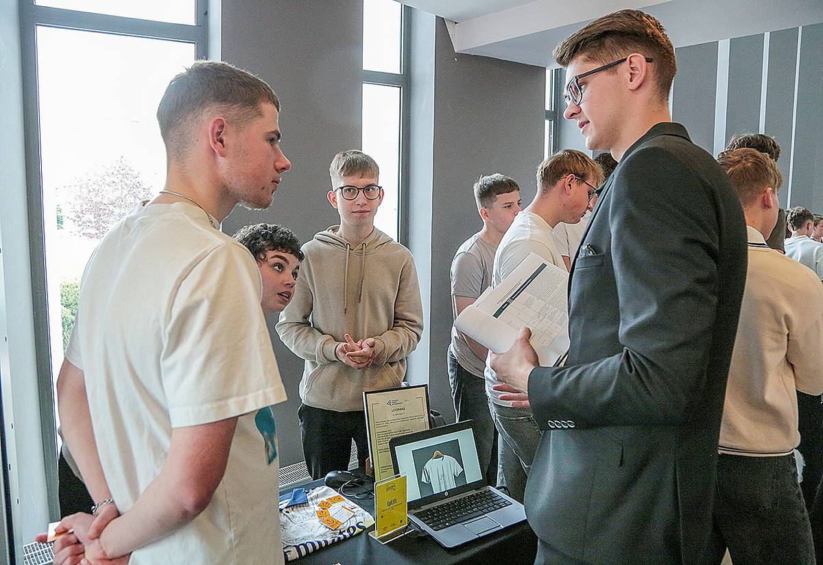 Verslo idėjos „UpLift“ nariai komisijos nariui pristato savo produktą.