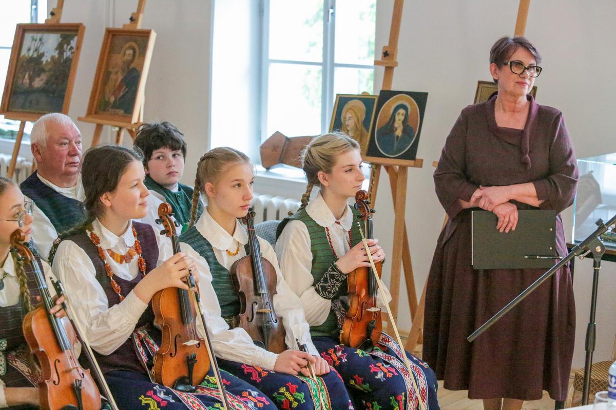 Jaunieji muzikantai, o už jų – Jono Gregoravičiaus kūryba.  Dešinėje – Audronė Šlyterienė.