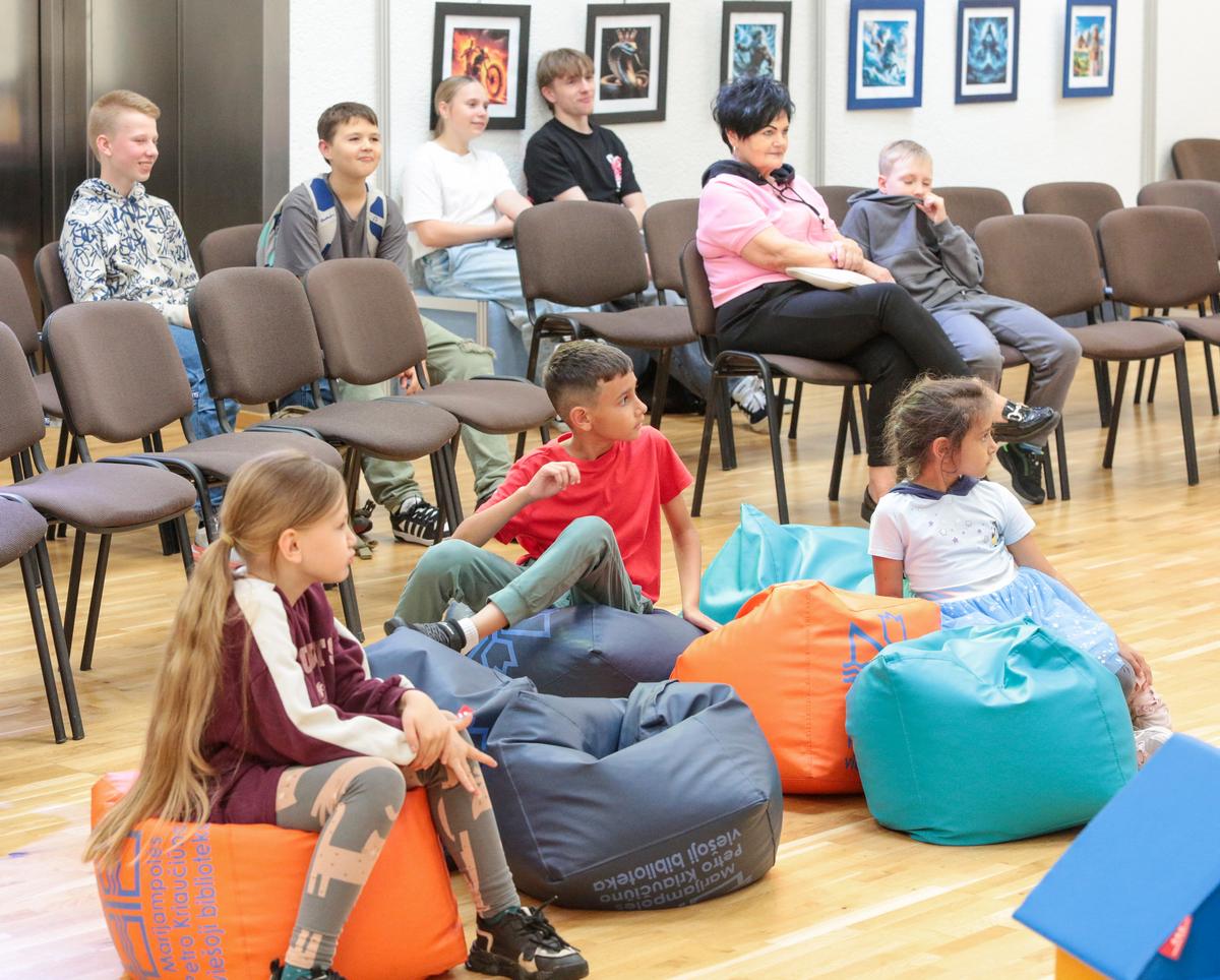Dėl prapliupusio lietaus renginio dalyviai šįkart buvo sukviesti į bibliotekos salę.
