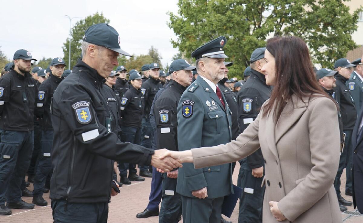 Premjerė Inga Ruginienė sveikina su apdovanojimu Raimundą Antanavičių.